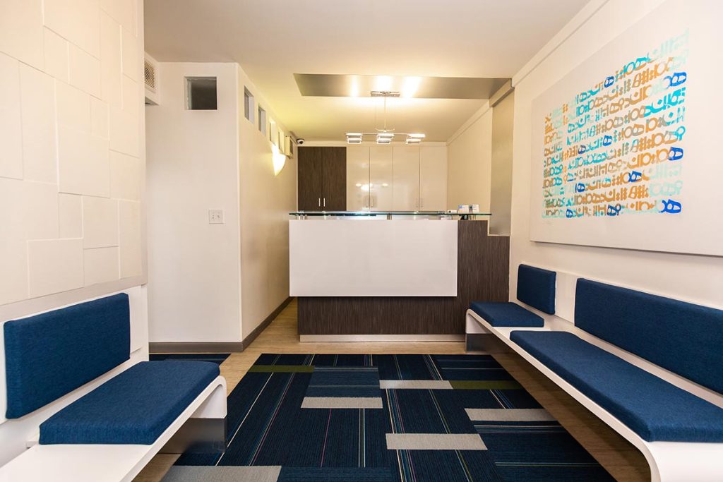 Sutton Place front desk area with blue sofa and decorations in dental office.