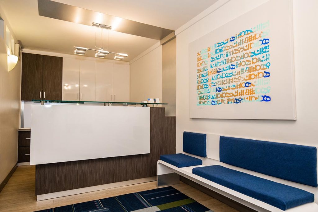 Sutton Place front desk area with blue sofa and decorations in dental office.