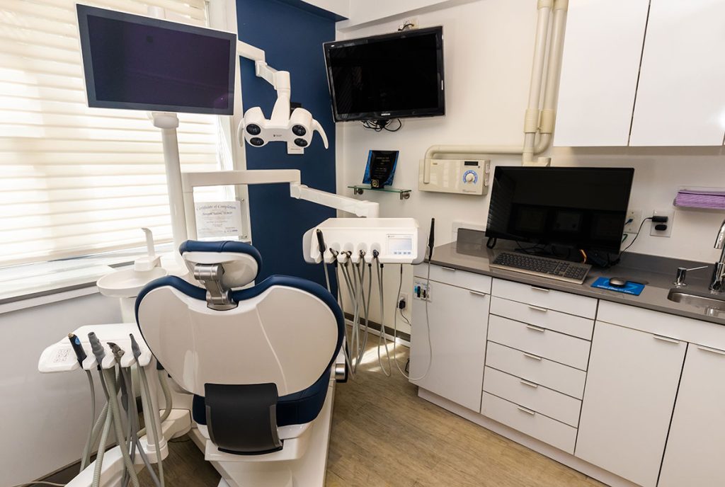 Dental chair with dental equipment in exam room.