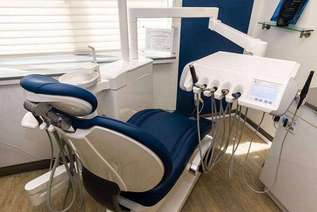 Dental chair with dental equipment in exam room.